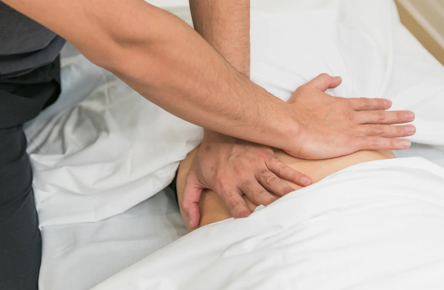Close-up of massage therapist applying firm pressure to the lower back during a therapeutic massage session at DC Chiropractic Markham